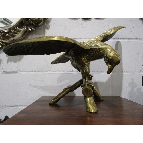 1039 - A large brass sculpture of a bird of prey perched on branch, 43cm tall