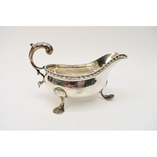 8052A - A silver sauce boat, gadrooned edge, shell relief feet, Longfield crest, scroll handle, with dents t... 