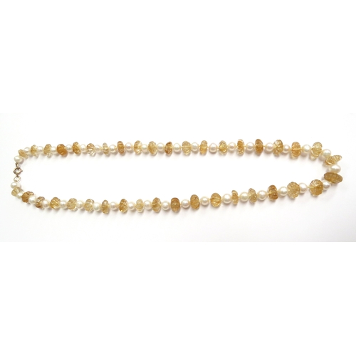 6150 - An alternating carved citrine and pearl necklace, with clasp stamped 9ct, 60cm long