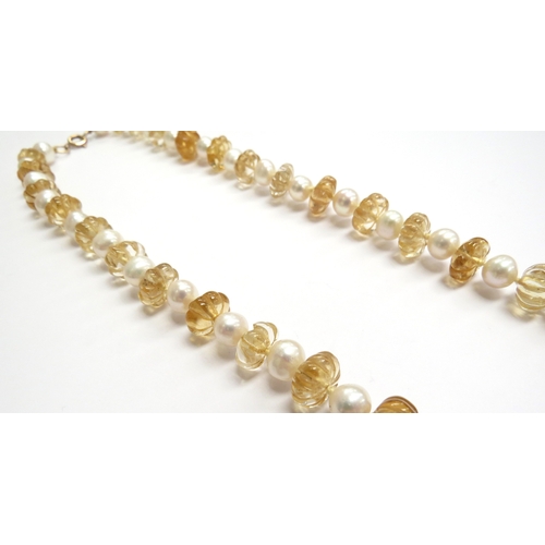 6150 - An alternating carved citrine and pearl necklace, with clasp stamped 9ct, 60cm long