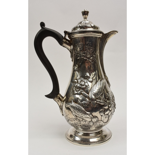8012 - A George III silver hot water jug/coffee pot.  The body decorated in high relief with birds, flowers... 