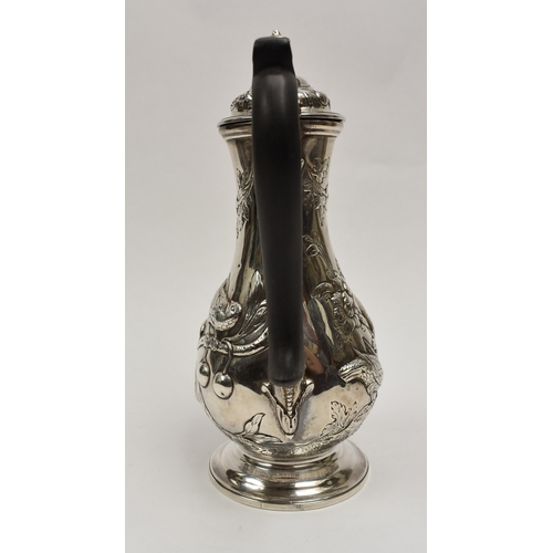 8012 - A George III silver hot water jug/coffee pot.  The body decorated in high relief with birds, flowers... 