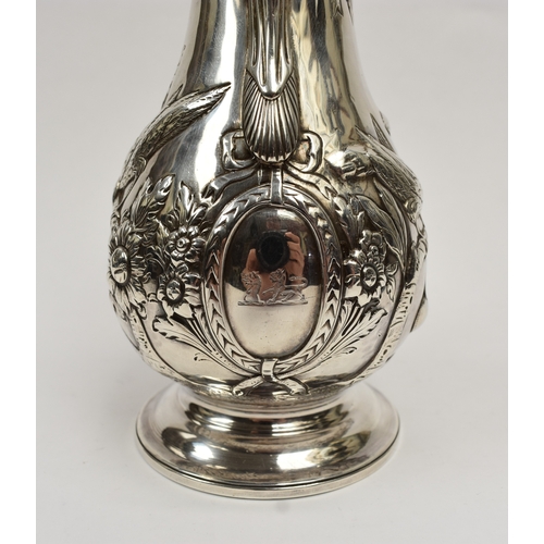 8012 - A George III silver hot water jug/coffee pot.  The body decorated in high relief with birds, flowers... 