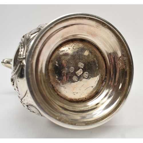 8012 - A George III silver hot water jug/coffee pot.  The body decorated in high relief with birds, flowers... 