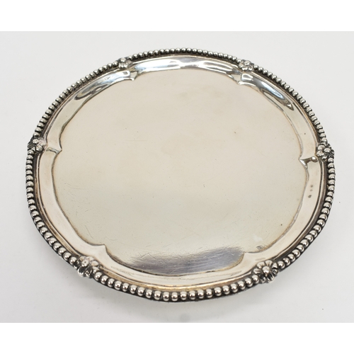 8009 - A George III Robert Jones I silver waiter with beaded and floral border, raised on three ball and cl... 