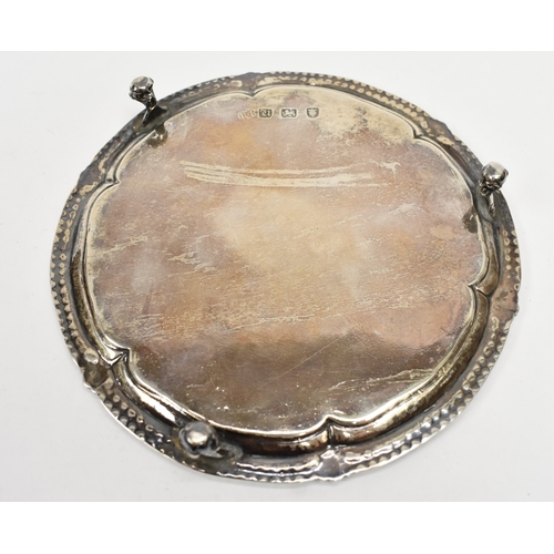 8009 - A George III Robert Jones I silver waiter with beaded and floral border, raised on three ball and cl... 