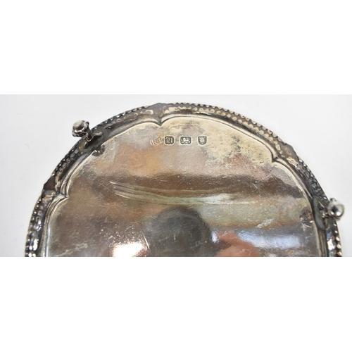 8009 - A George III Robert Jones I silver waiter with beaded and floral border, raised on three ball and cl... 
