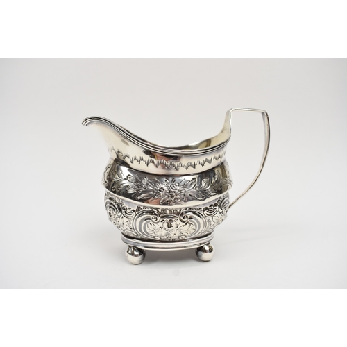8013 - A George III matched silver three piece tea set of highly ornate form with all-over engraved and emb... 