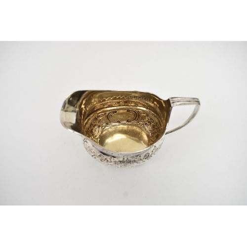 8013 - A George III matched silver three piece tea set of highly ornate form with all-over engraved and emb... 