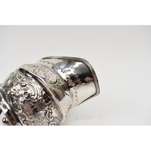 8013 - A George III matched silver three piece tea set of highly ornate form with all-over engraved and emb... 