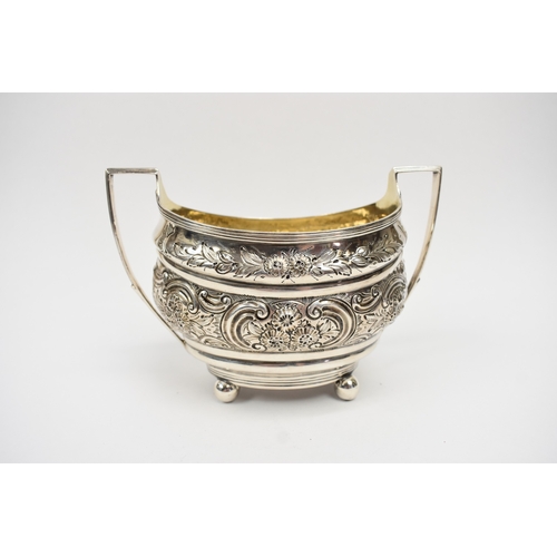 8013 - A George III matched silver three piece tea set of highly ornate form with all-over engraved and emb... 
