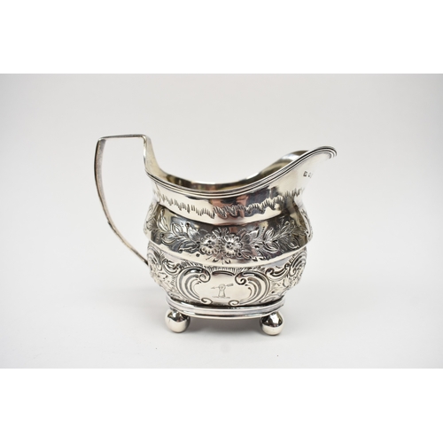 8013 - A George III matched silver three piece tea set of highly ornate form with all-over engraved and emb... 