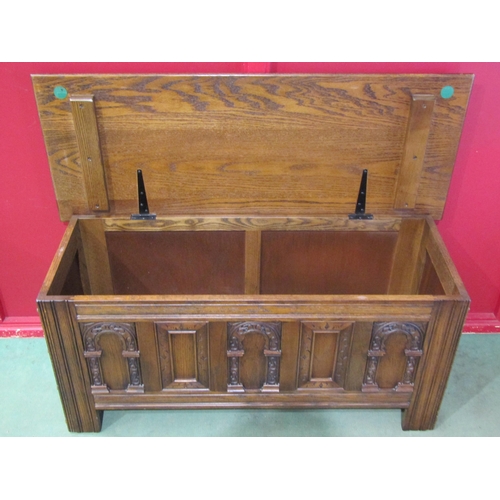 4016 - An 'Old Charm' Tudor style oak chest with carved decoration, the hinged lid over stile feet, 52cm ta... 