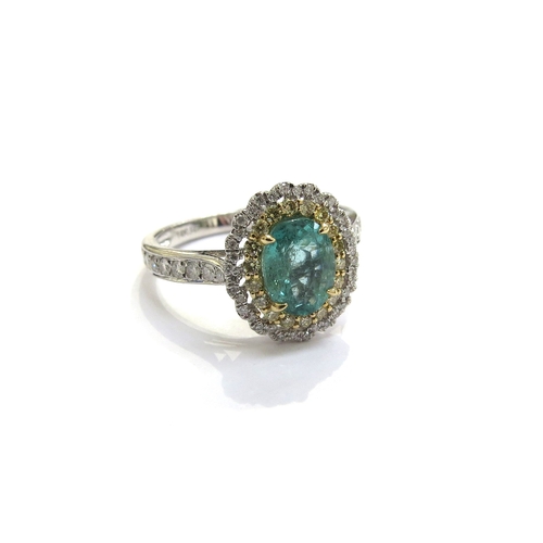 6122 - A 14ct white gold emerald and diamond ring the central oval emerald framed in turn by yellow and whi... 