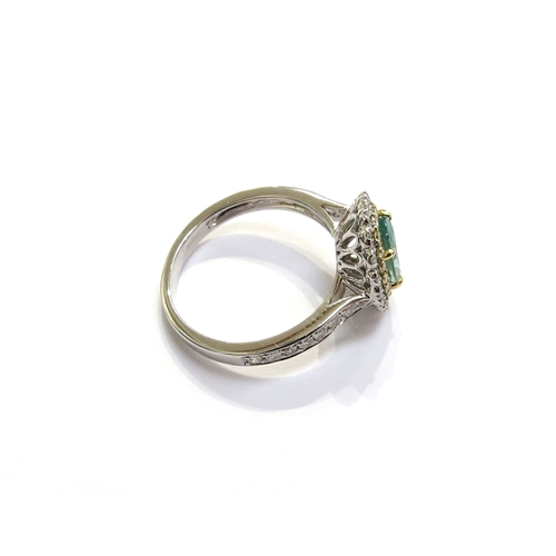 6122 - A 14ct white gold emerald and diamond ring the central oval emerald framed in turn by yellow and whi... 