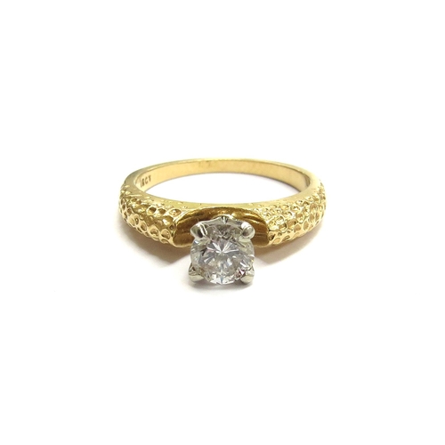 6058 - A diamond solitaire ring in four claw mount within a textured shank, 18ct. Size M/N, 4g