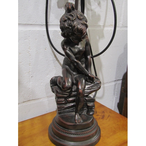 1027 - A modern table lamp as a seated cherub, floral frilled shade, 56cm tall