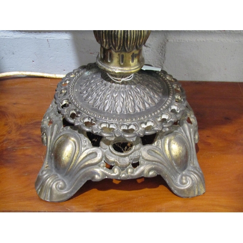 1037 - A table lamp, the red globular glass shade over an ornate brass base
