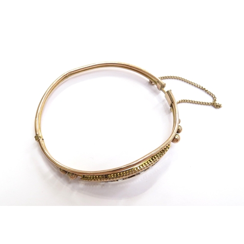 6011 - A 9ct gold hinged bangle, clasp a/f, set with pale blue sapphires (one missing), 6.4g