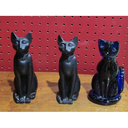 4059 - A Bristol blue glass cat, a pair of resin Egyptian cats, a paperweight with two dolphins, a resin pa... 