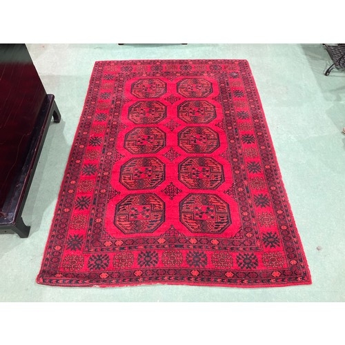4512 - A red and orange ground geometric patterned rug, 196cm x 140cm