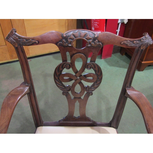 4013 - A Georgian mahogany open armchair with carved backrest, the scroll arms over a leather seat on chamf... 