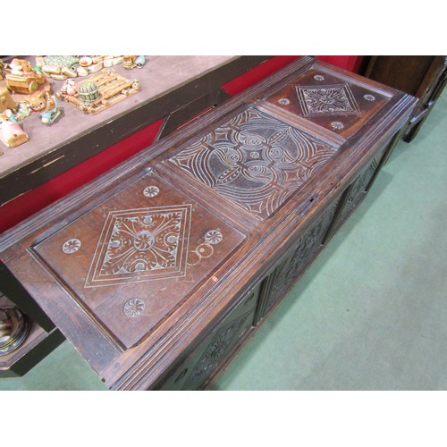 4009 - A three panel coffer with carved decoration on brass castors, 62cm tall x 142cm wide x 54cm deep