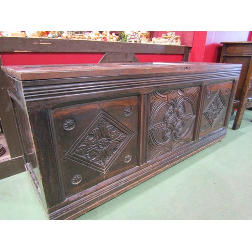 4009 - A three panel coffer with carved decoration on brass castors, 62cm tall x 142cm wide x 54cm deep