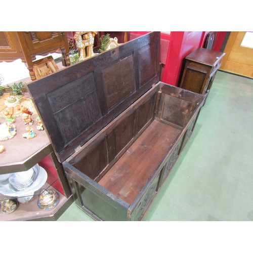 4009 - A three panel coffer with carved decoration on brass castors, 62cm tall x 142cm wide x 54cm deep