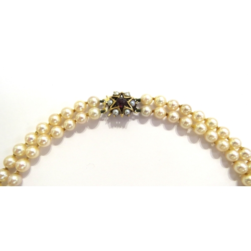 6151 - A double strand pearl necklace with a 9ct gold garnet and pearl star shaped clasp, 41cm long