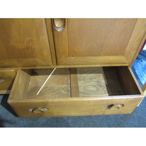 1007 - An Ercol Windsor light elm sideboard, raised on castors, three cupboards over two drawers, 76cm tall... 