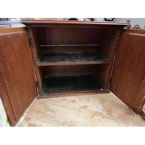 2002 - A Gothic oak wall mounting cabinet with arch panel doors