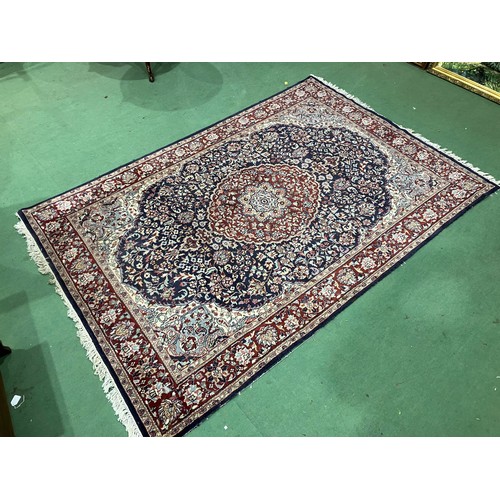 4452 - A red and blue ground Persian wool rug, central floral medallion, multiple borders, tasselled ends, ... 