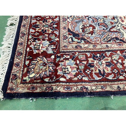 4452 - A red and blue ground Persian wool rug, central floral medallion, multiple borders, tasselled ends, ... 