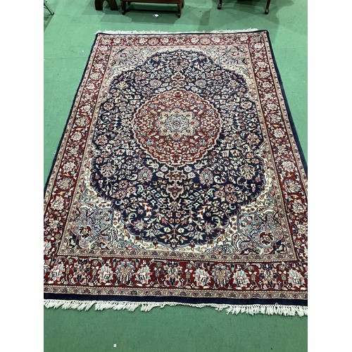 4452 - A red and blue ground Persian wool rug, central floral medallion, multiple borders, tasselled ends, ... 