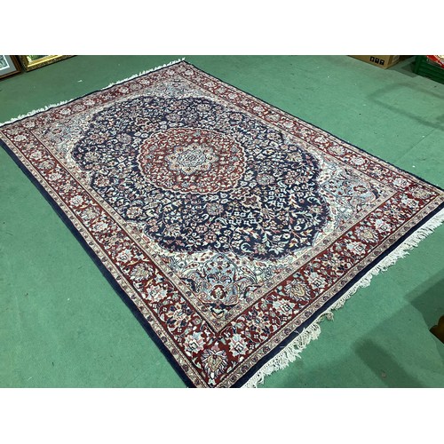 4452 - A red and blue ground Persian wool rug, central floral medallion, multiple borders, tasselled ends, ... 