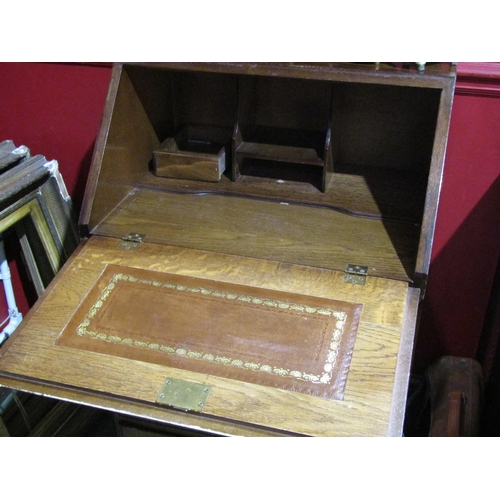 4057 - An early-mid 20th Century oak bureau, four drawers over bracket feet, gilt tooled leather writing su... 