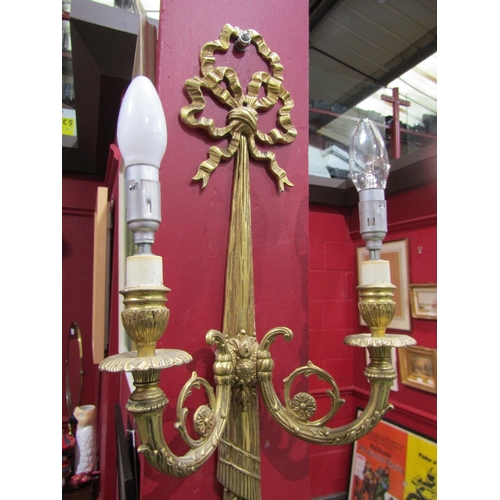 4062 - A pair of gilt metal ribbon and swag twin arm wall sconces, 60cm tall