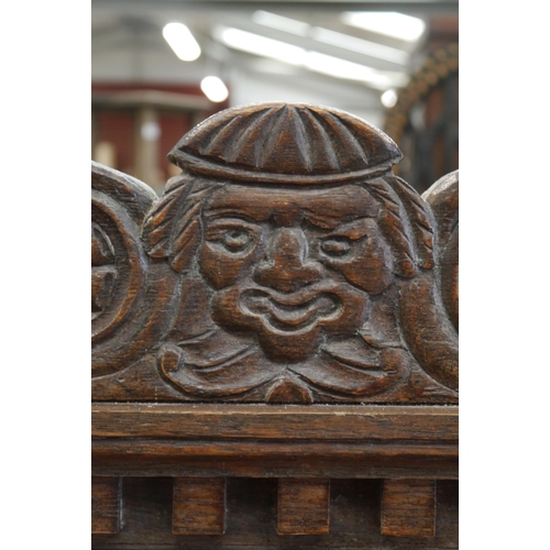 2001 - An 18th Century carved oak settle, three heraldic panels to back and front, rising seat, outswept ar... 