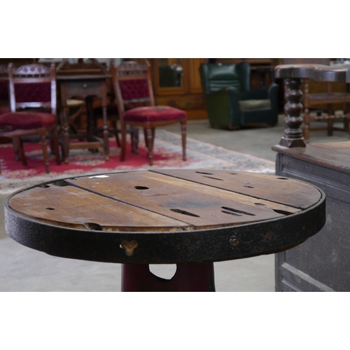 2002 - A circular oak topped table on industrial cast iron base, 56cm diameter