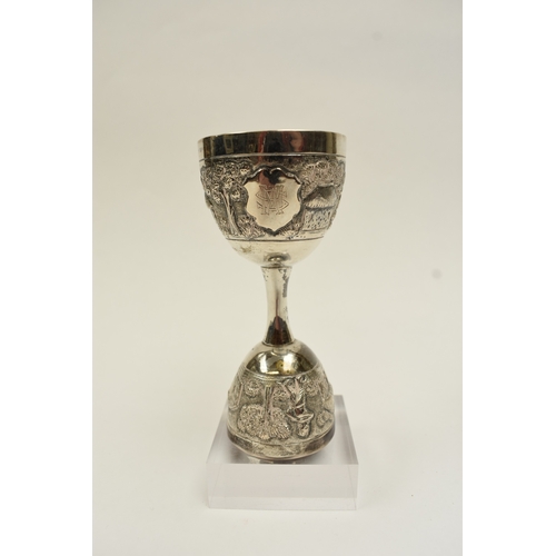 8022 - A two cup measure, marked silver with tribal hut and vegetation decoration, 10cm tall, 80g
