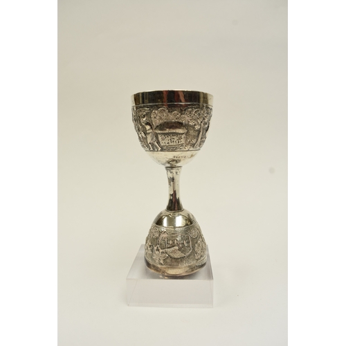 8022 - A two cup measure, marked silver with tribal hut and vegetation decoration, 10cm tall, 80g