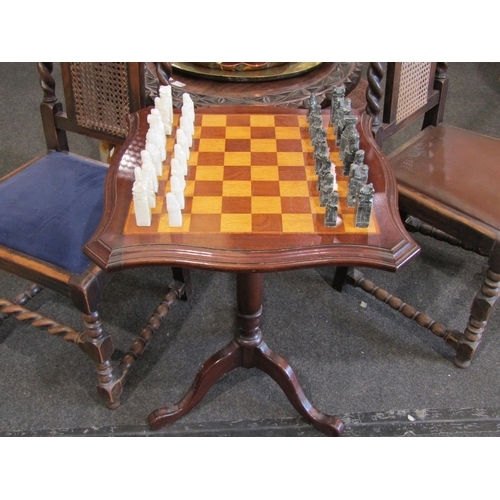 1109 - A tripod mahogany chess table with carved soapstone chess pieces