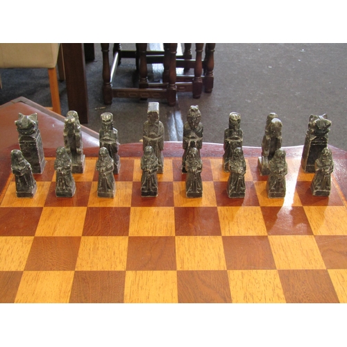 1109 - A tripod mahogany chess table with carved soapstone chess pieces