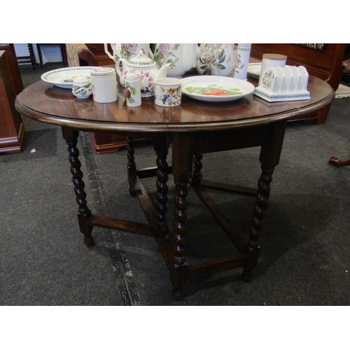 1103 - An early 20th Century oak oval top gateleg table on barley twist legs, 47