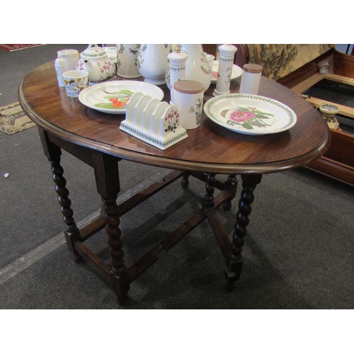 1103 - An early 20th Century oak oval top gateleg table on barley twist legs, 47