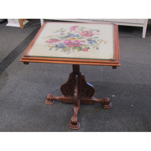 1116 - An oak tilt-top table, floral tapestry top under glass, carved legs and supports, 57cm tall x 56cm w... 