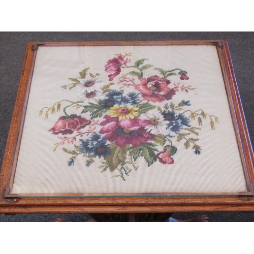 1116 - An oak tilt-top table, floral tapestry top under glass, carved legs and supports, 57cm tall x 56cm w... 