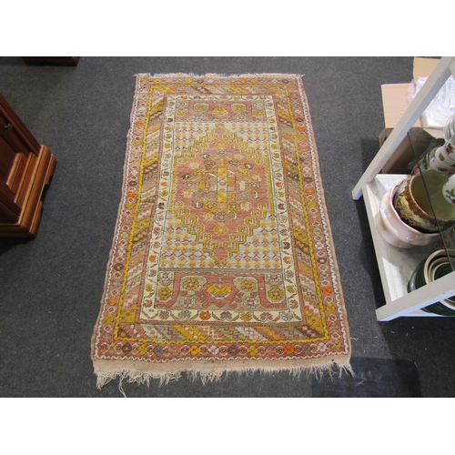 1119 - A pink ground Eastern wool rug, yellow and pink with borders, central diamond medallion, 100cm x 160... 