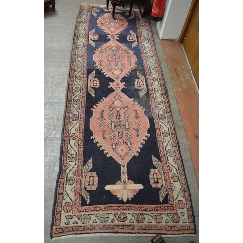 8553 - A 20th Century hand-woven runner rug with blue and red geometric pattern, worn in areas, 315cm x 110... 